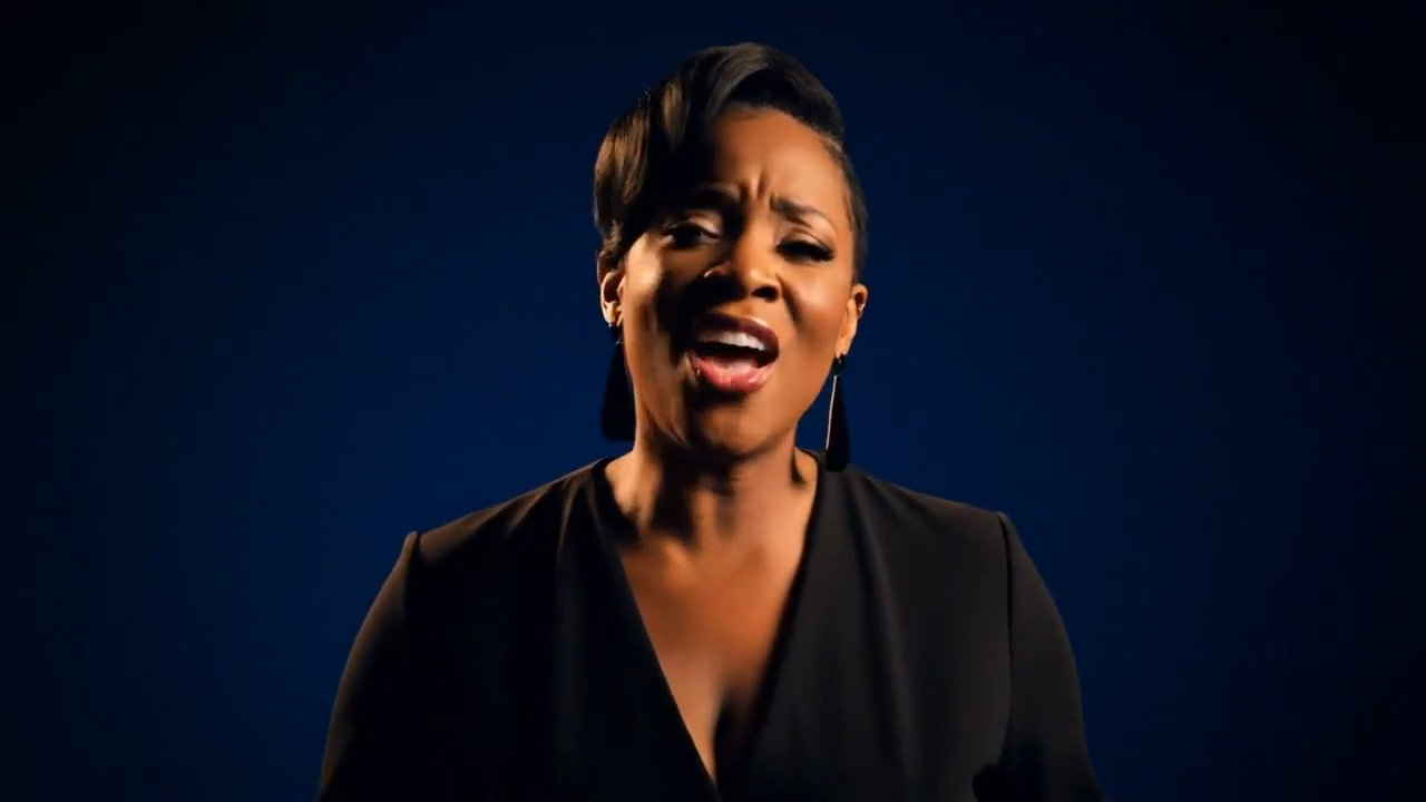 A woman singing to the camera